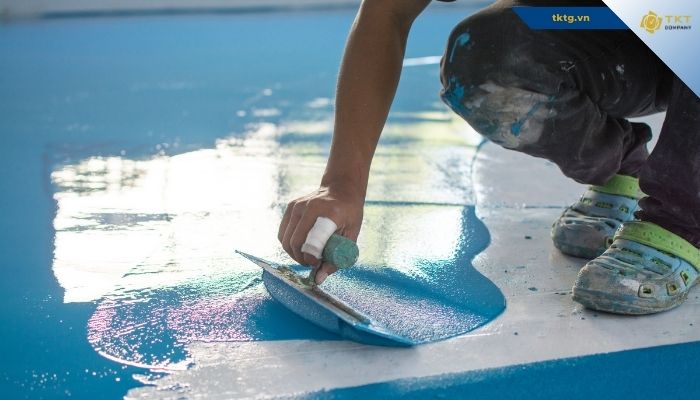 Thợ thi công lớp phủ gốc polyurethane trên sàn bê tông
