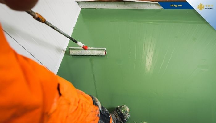 Thợ dùng rulo lăn sơn epoxy hệ lăn lên bề mặt nền nhà xưởng