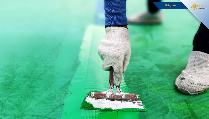 Công nhân xử lý bề mặt nền trước khi phủ sơn epoxy hệ lăn